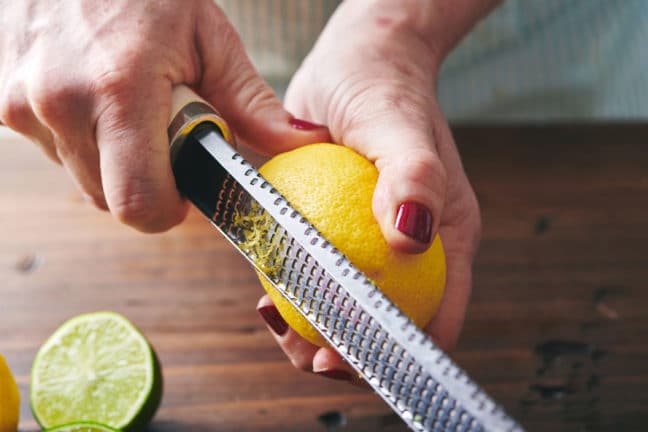 Zesting a fresh lemon with a Microplane