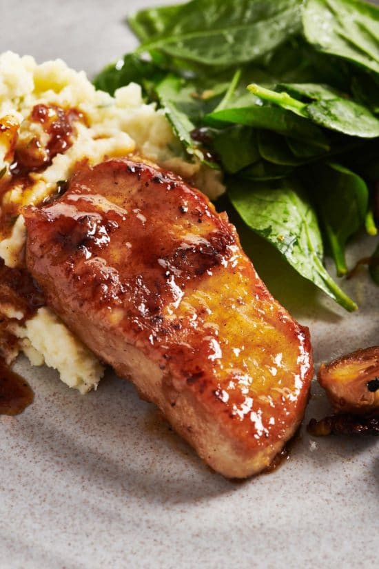 Honey Garlic Pork Chops with mashed potatoes and spinach on plate