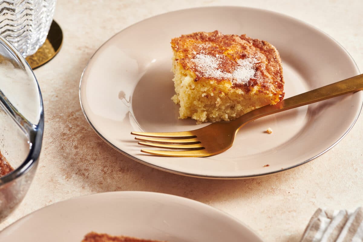 Slice of Apple Coffee Cake on a plate with a golden fork.