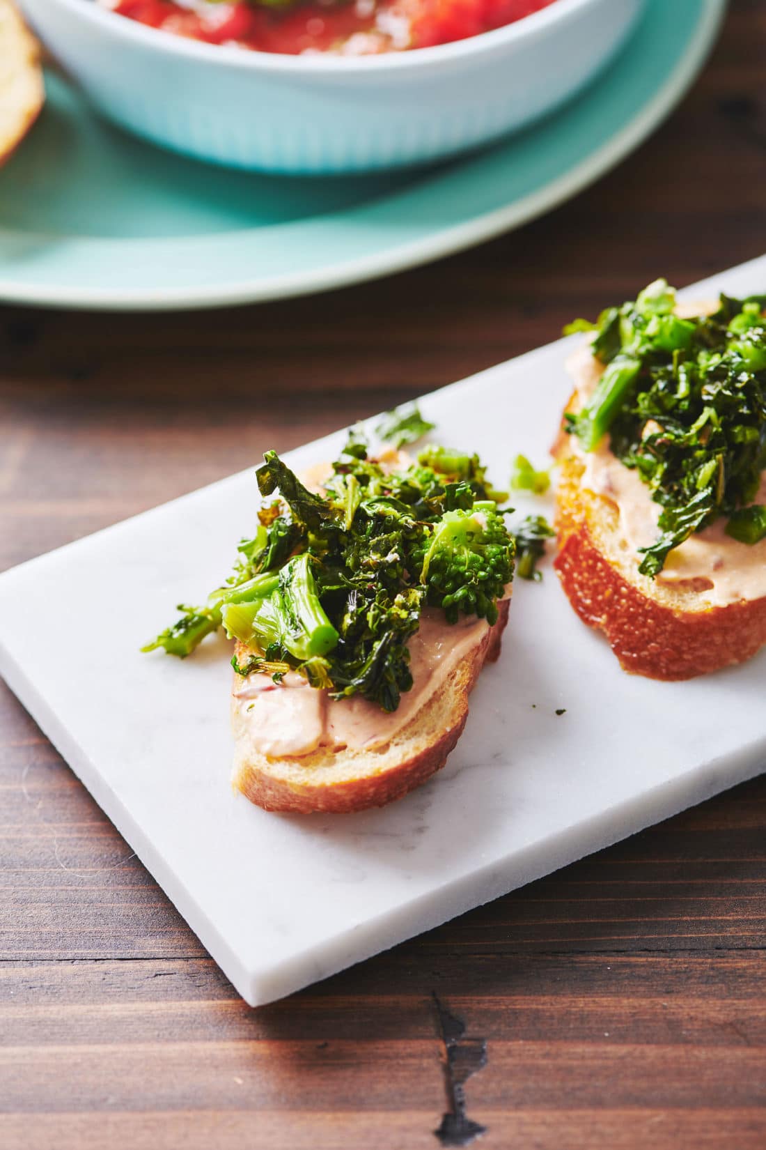 Broccoli Rabe Crostini with Chipotle Sauce on a white plate.