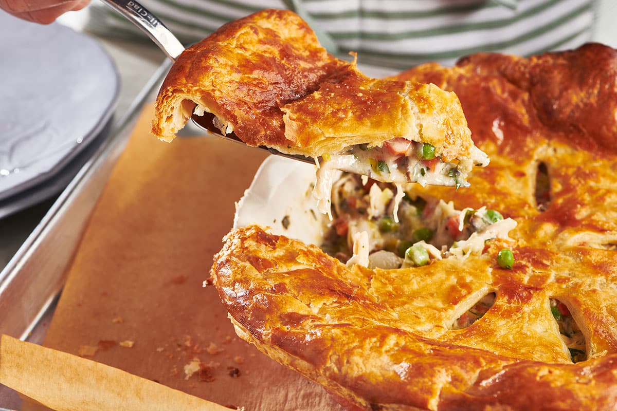 Serving slice of chicken pot pie.