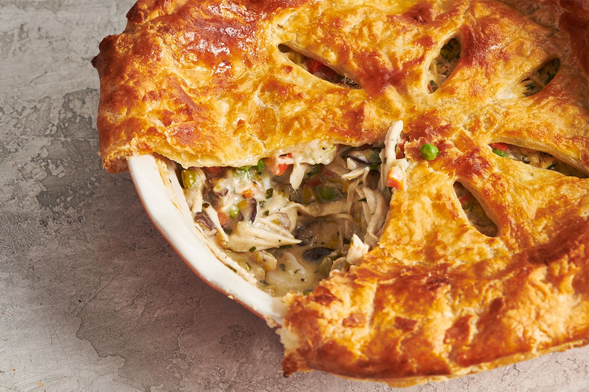 Homemade chicken pot pie in dish on table.