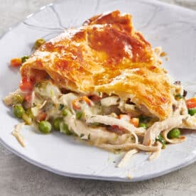 Slice of chicken pot pie on white plate.