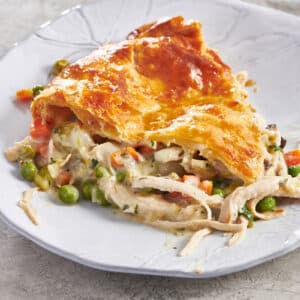 Slice of chicken pot pie on white plate.
