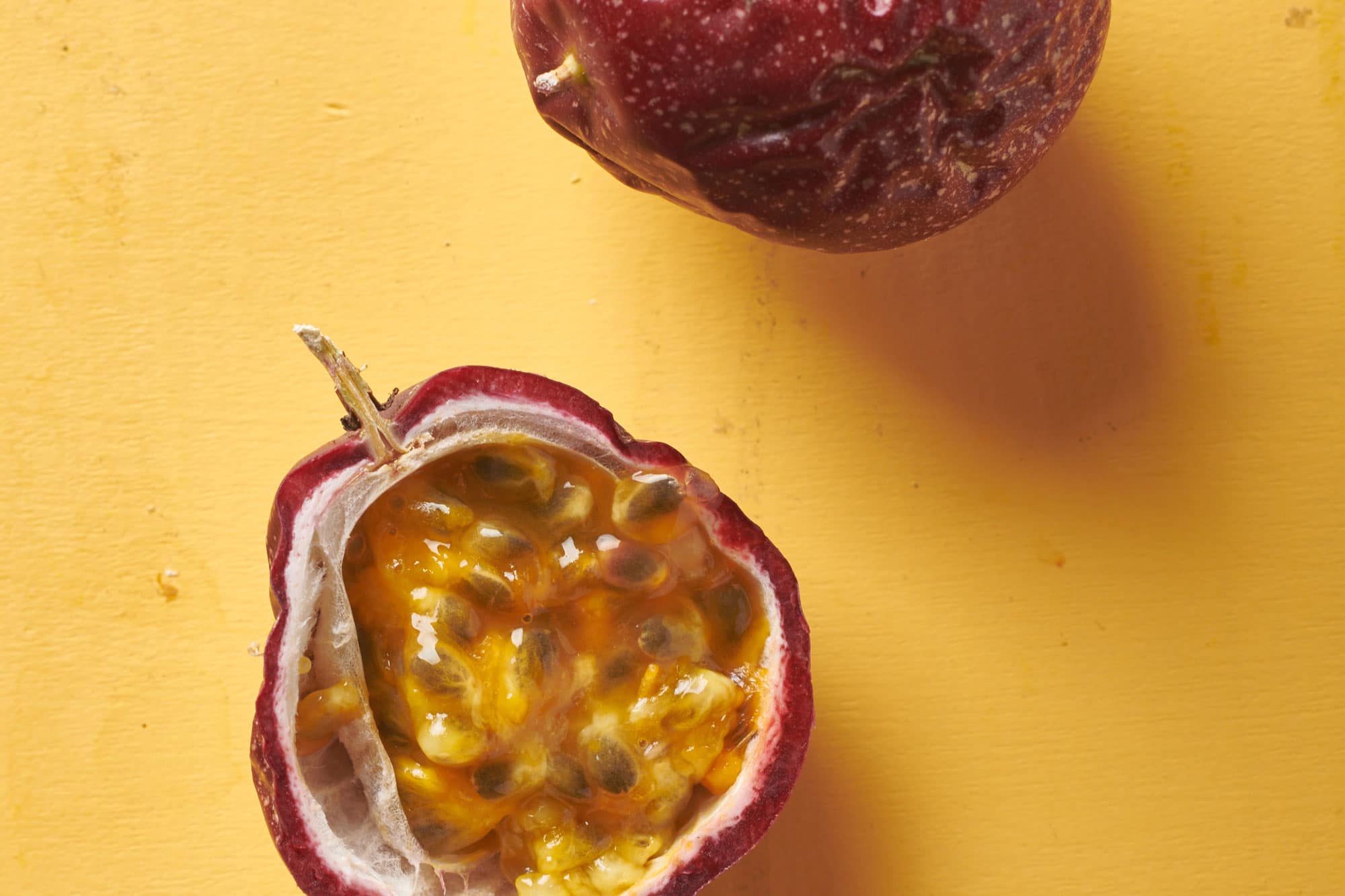 Half of a passion fruit with theseeds and juice inside.