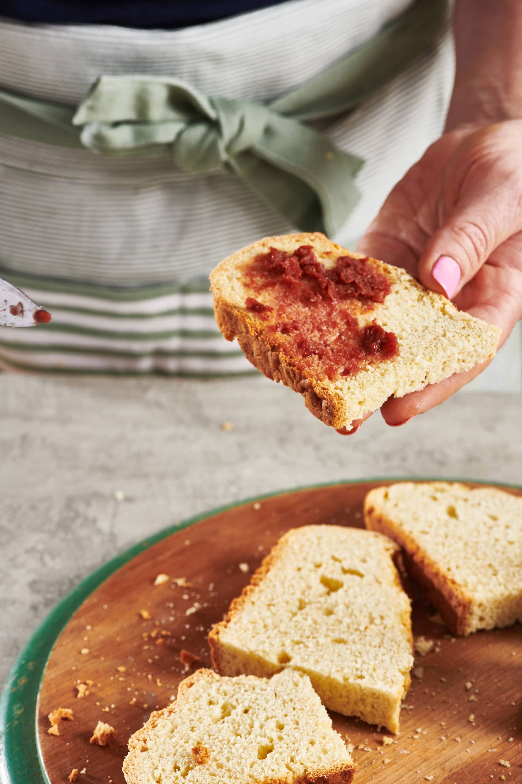 Woman spreading jam onto a slice of Irish Soda Bread.