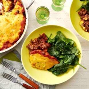 Tamale Pie and greens on plates.