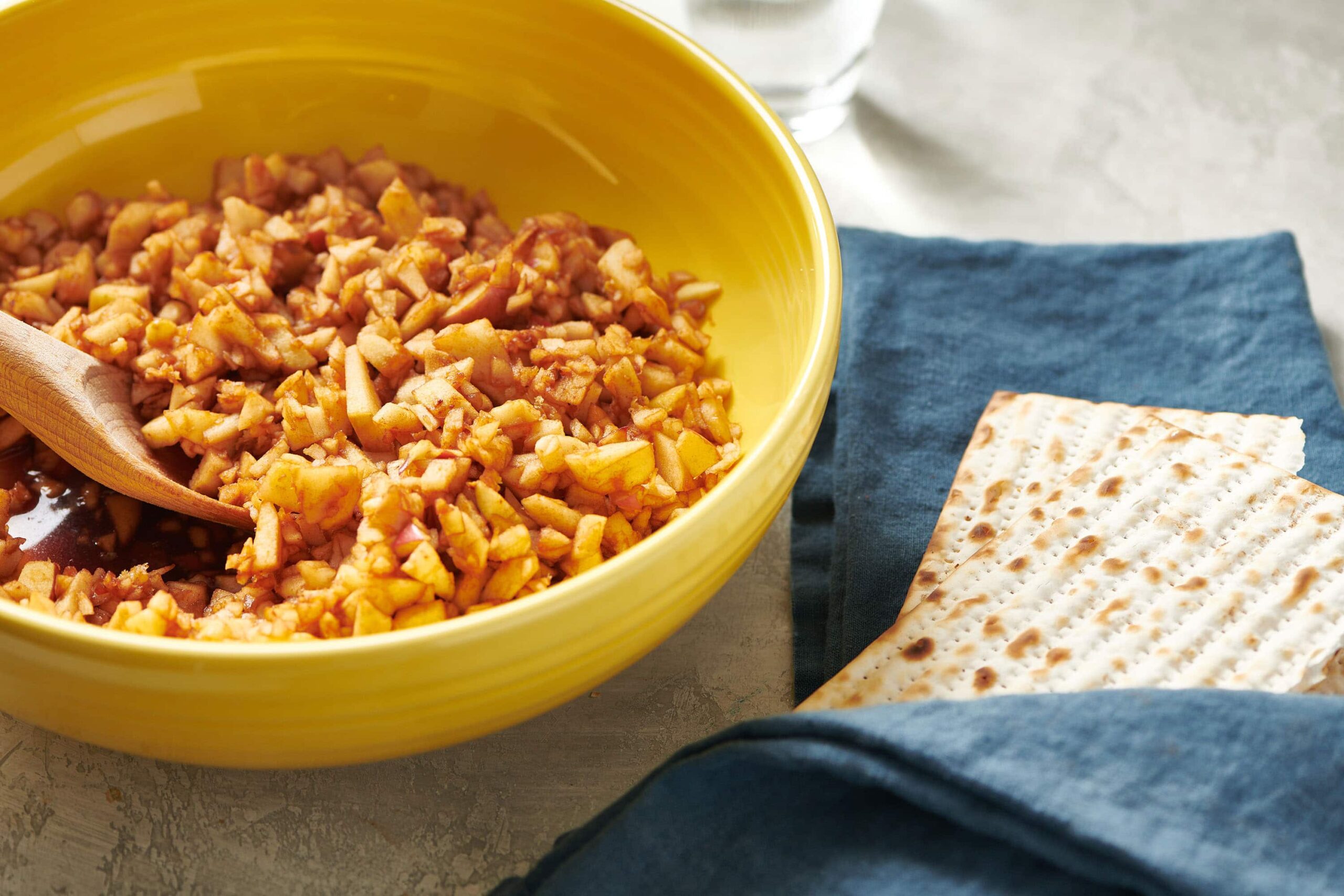 Yellow bowl of Charoset next to matzoh.