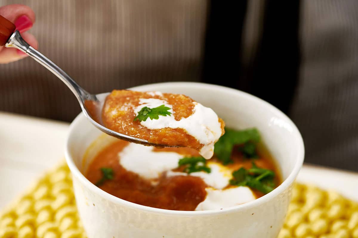 Spoon with a scoop of Moroccan Carrot and Cauliflower Soup.