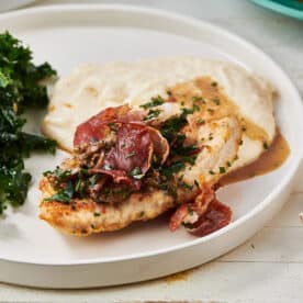 Turkey Marsala on a white plate with greens.