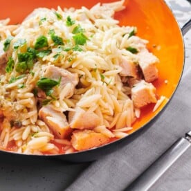 Chicken Piccata Orzo Salad in an orange, handled bowl.