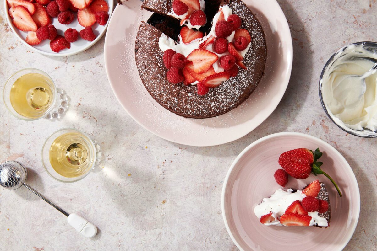 Fudgy Chocolate Cake and strawberries on plates.