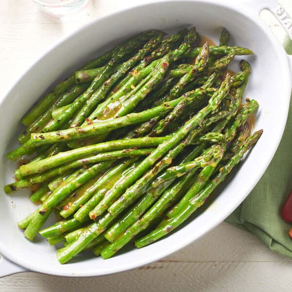 Grilled Asparagus with Vinaigrette in serving dish on table.