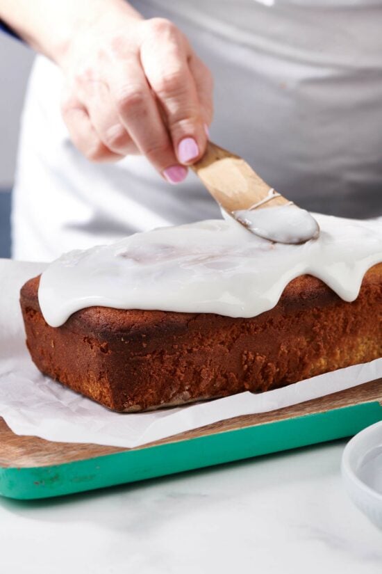 Woman icing a Lemon Cake.