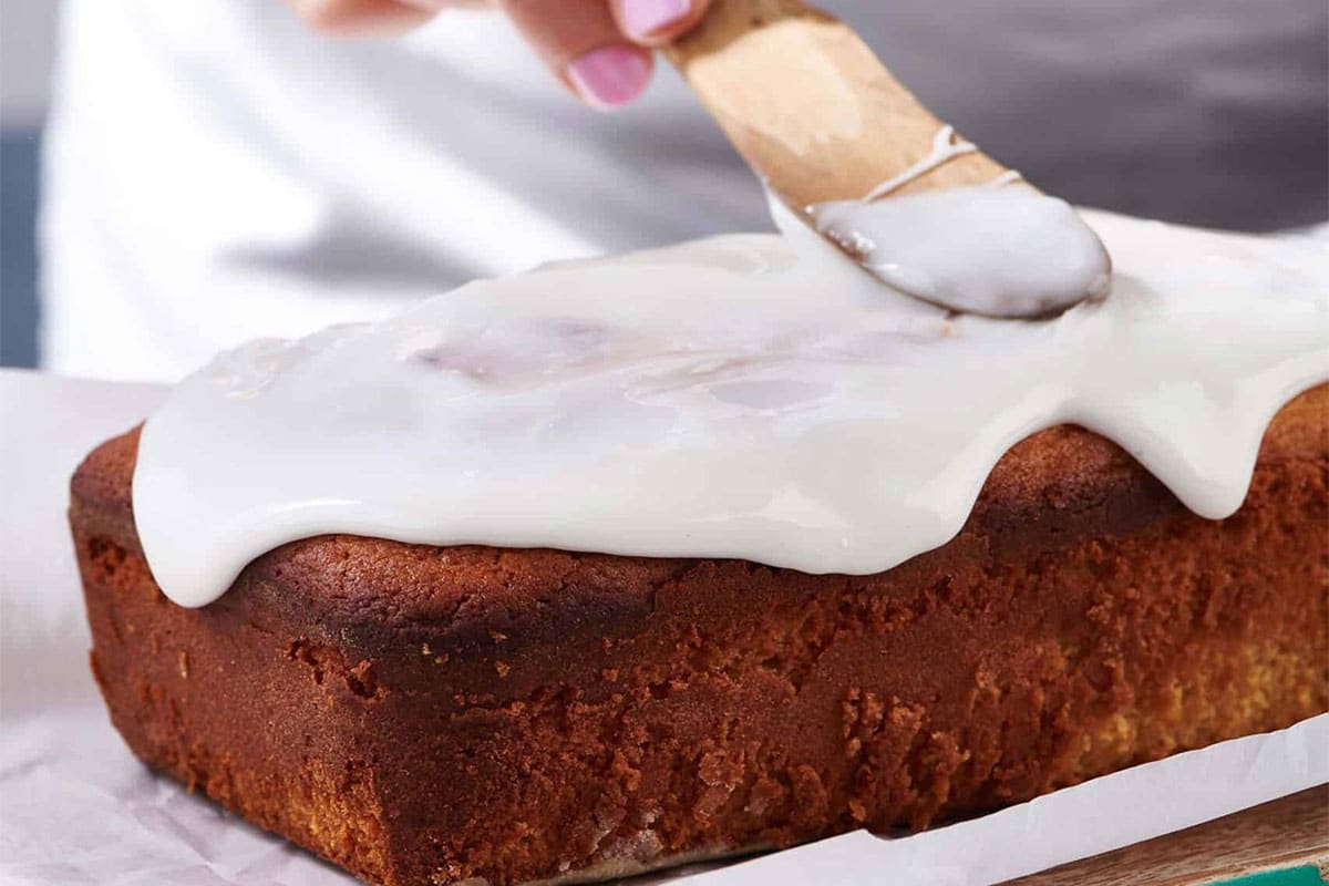 Woman icing a Lemon Cake.