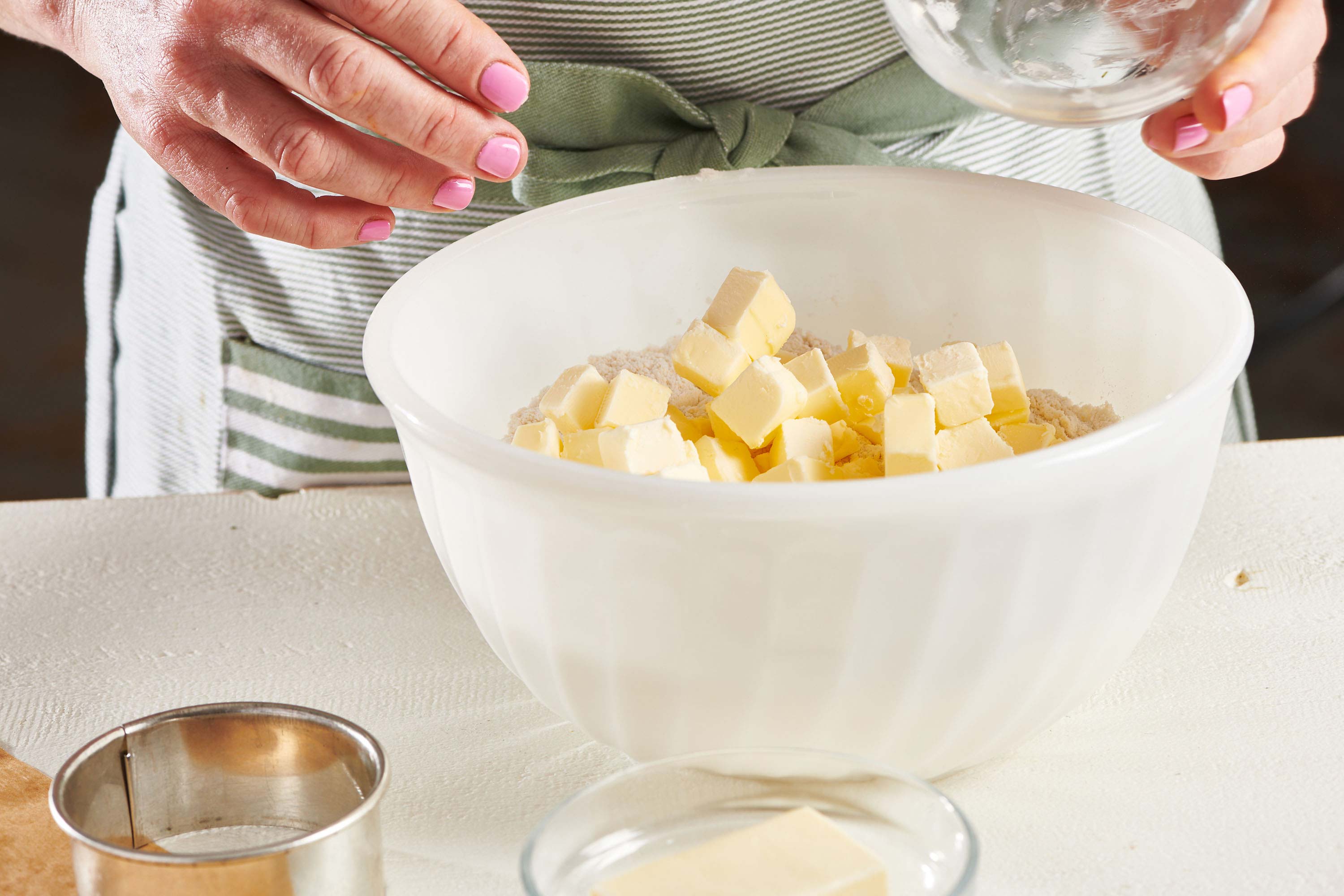 Woman with a bowl of butter and dry ingredients.