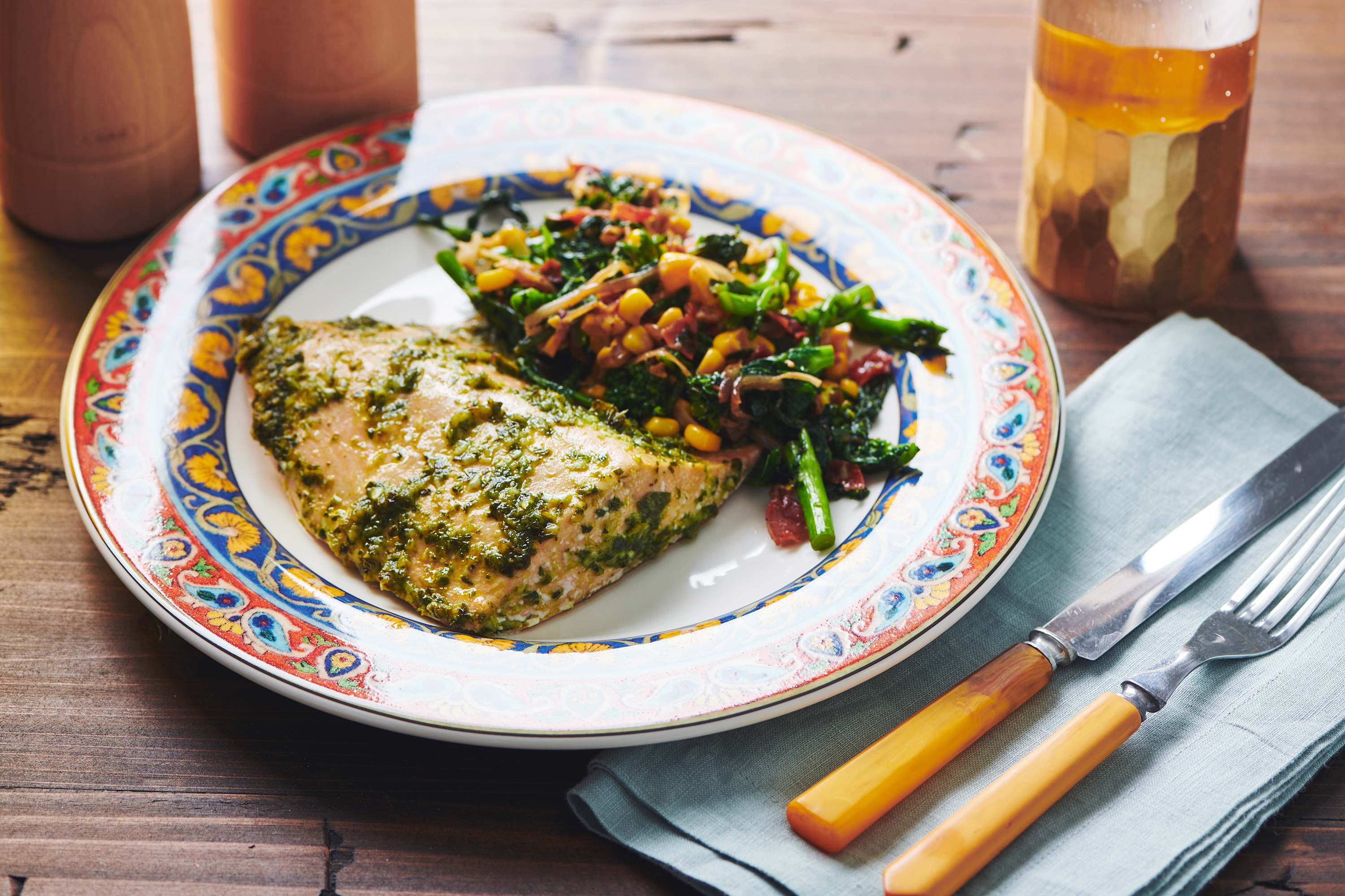 Salmon with Chimichurri Sauce on a plate with a colorful vegetable side.