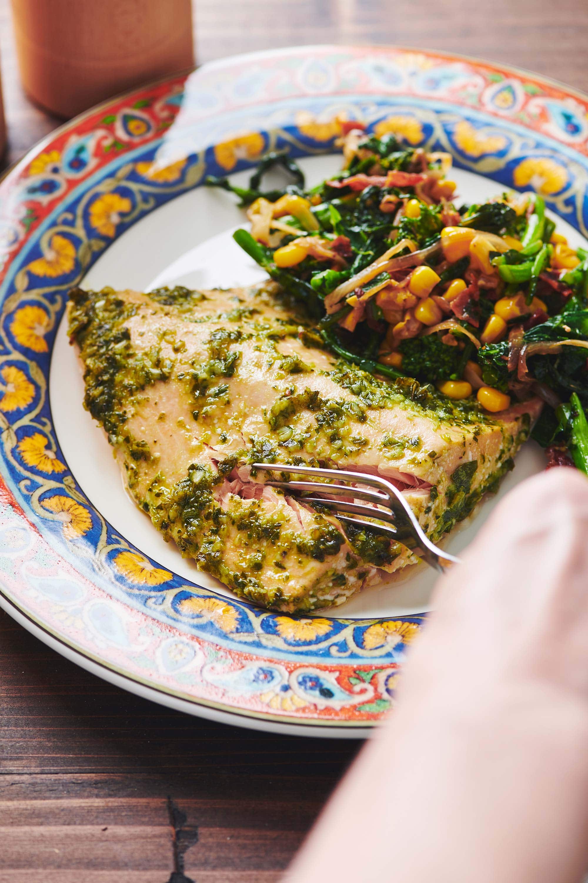 Fork cutting into Salmon with Chimichurri Sauce.