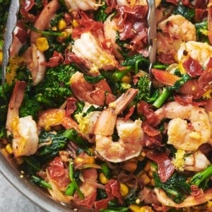 Sauteed Shrimp with Vegetables topped with prosciutto in a skillet.