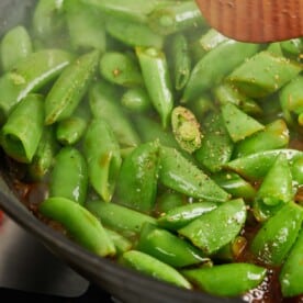 Seasoned Soy Glazed Sugar Snap Peas cooking in pan.