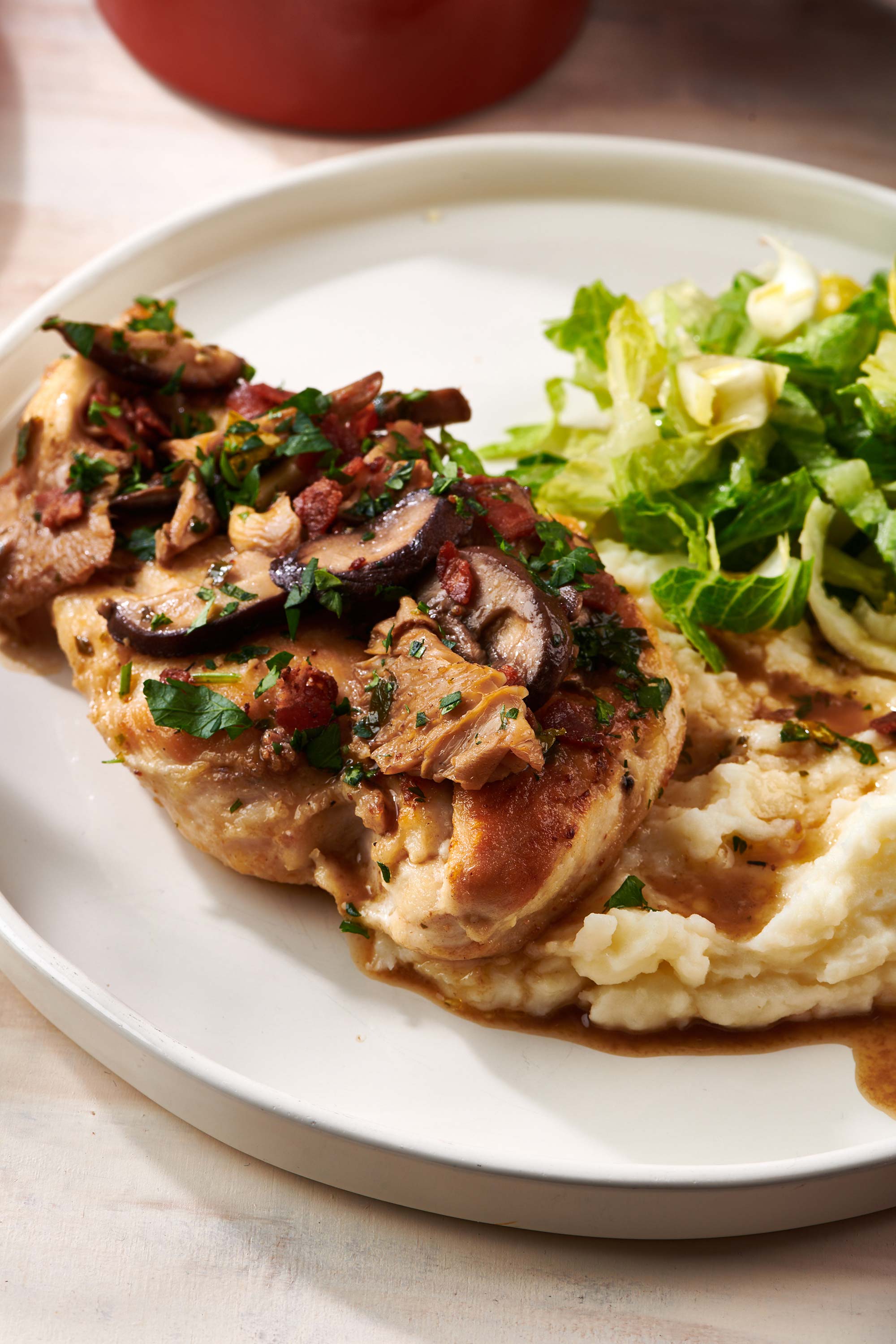 Chicken Marsala, mashed potatoes, and salad on a plate.