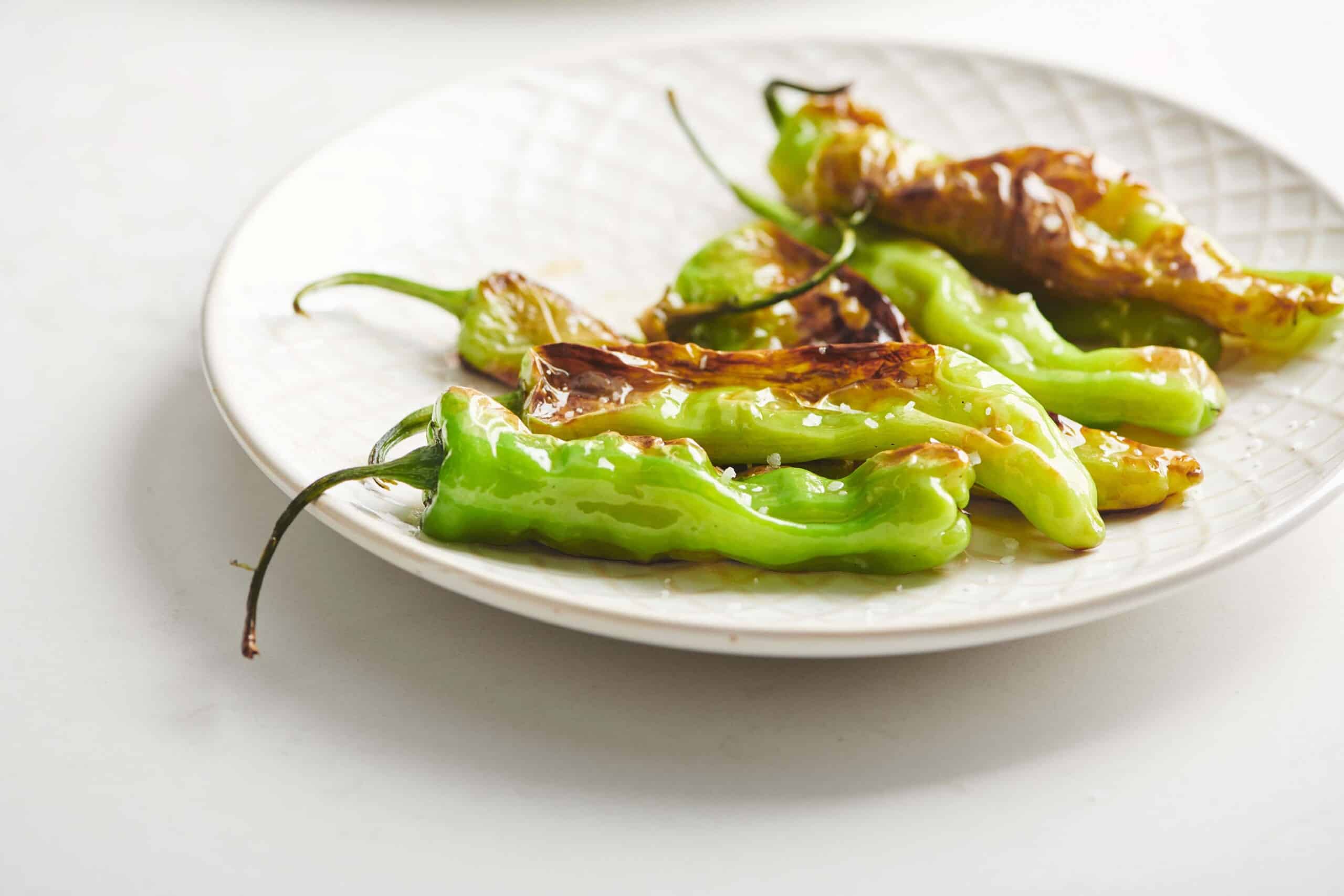Cooked Shishito Peppers topped with salt.
