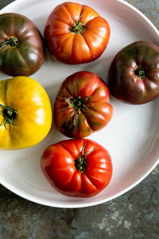 Variety of heirloom tomatoes on white plate.