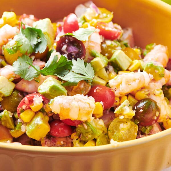 Salad with shrimp and avocado in yellow serving bowl.