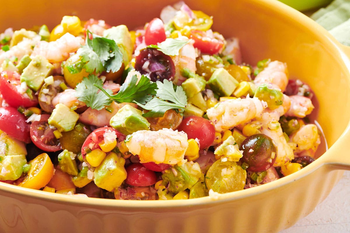 Salad with shrimp and avocado in yellow serving bowl.
