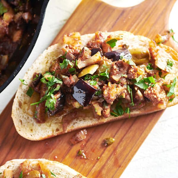 Caponata bruschetta on a wooden board.