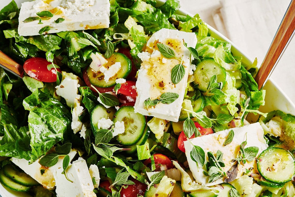 Greek Salad tossed with Greek dressing and topped with feta and oregano leaves.