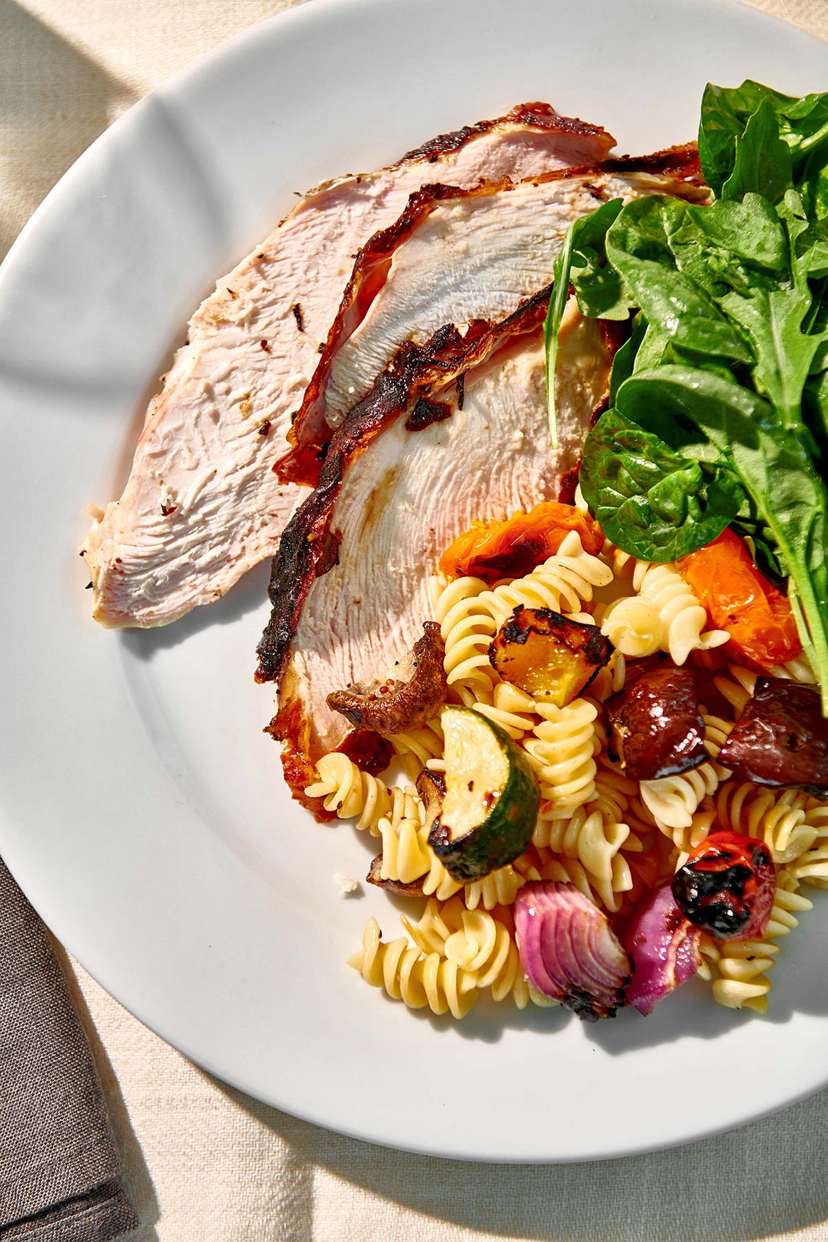 Plate with sliced turkey breast and salads.