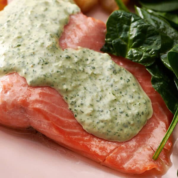 Poached Salmon topped with Cilantro Sauce on a plate.