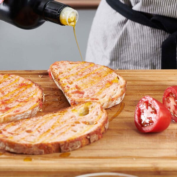 Olive oil drizzling onto slices of bread.