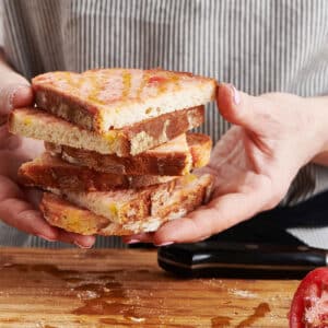 Woman holding a stack of pan con tomate.