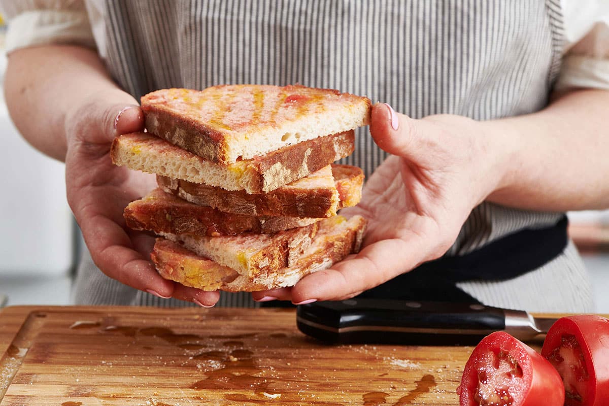 Woman holding a stack of pan con tomate.