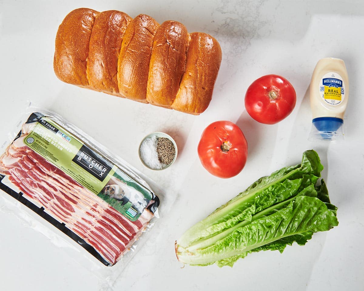 Bread, bacon, lettuce, tomato, and other ingredients for a BLT.