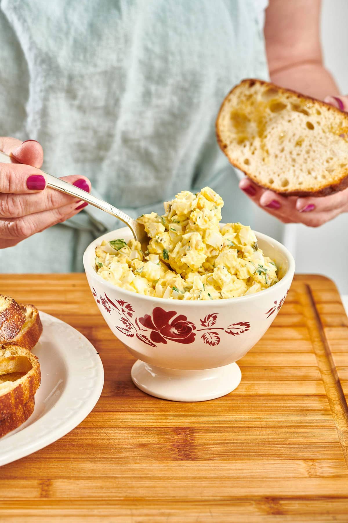 Woman scooping Egg Salad from a bowl.