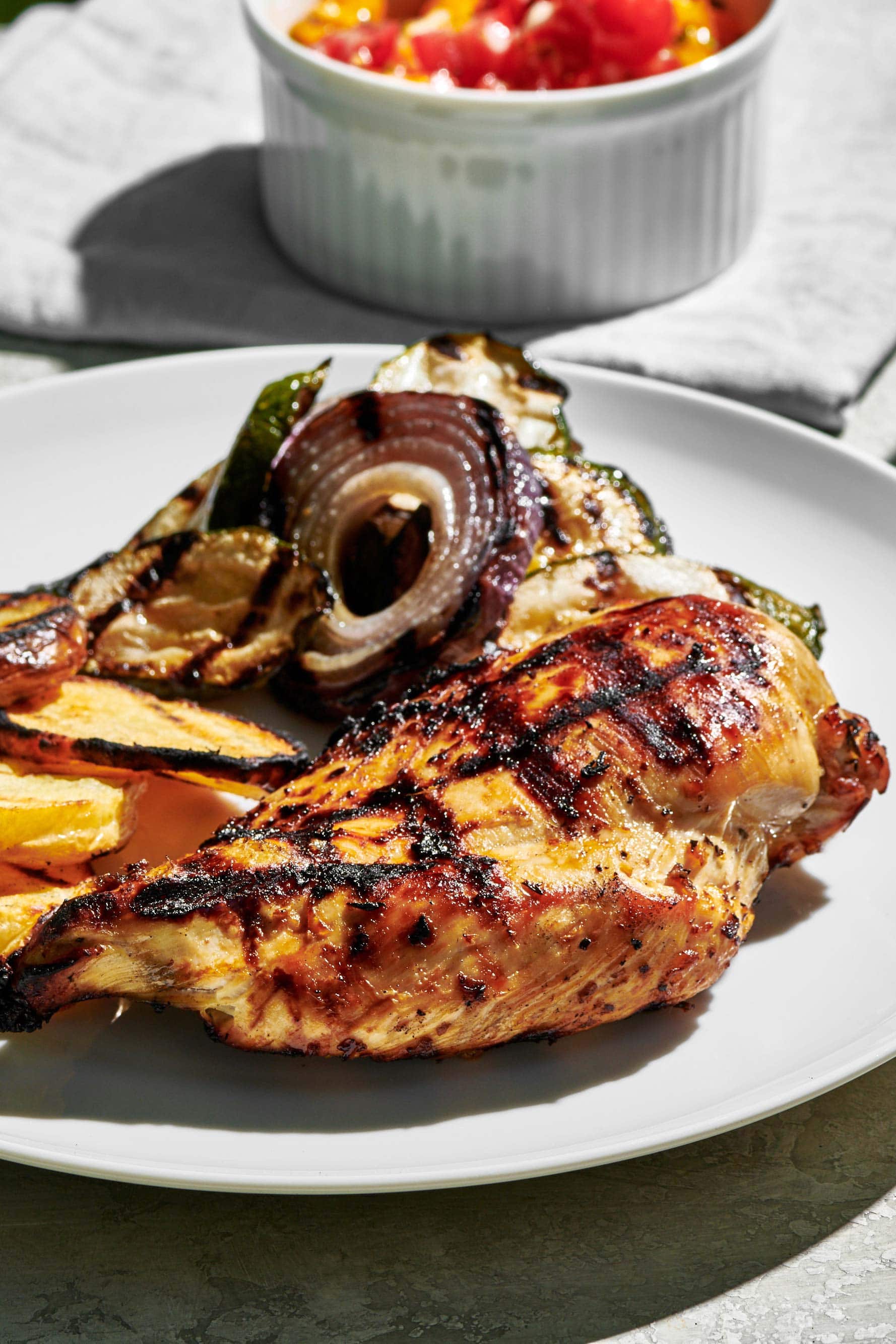 Grilled Chicken Breast on a plate with grilled vegetables.
