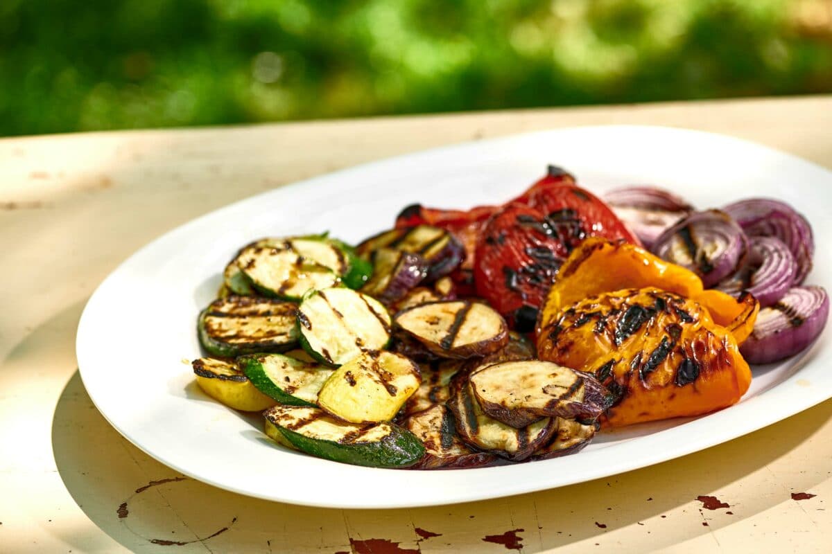 Grilled Vegetables on a white oval platter on a table.