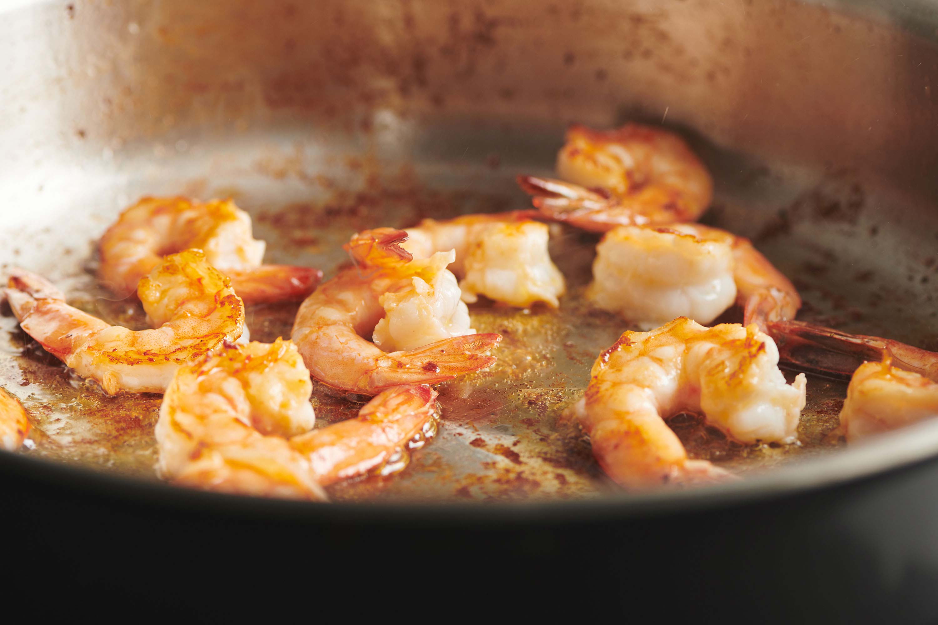 Shrimp sauteing in pan on the stove.