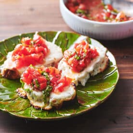 Green plate of Pizza Bruschetta.