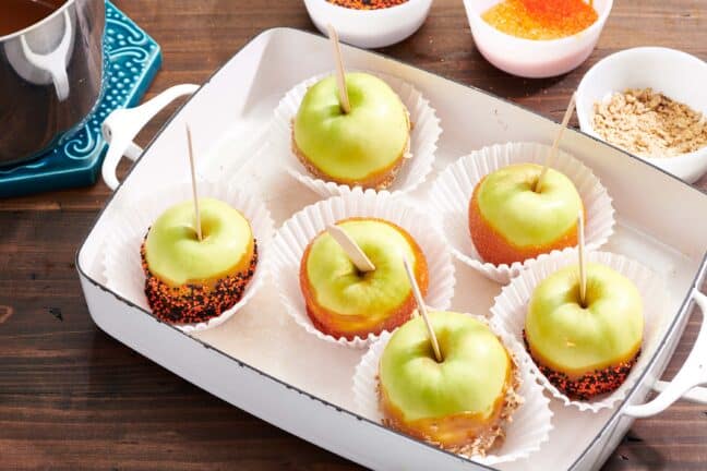 Baking pan of Caramel Apples with different toppings.