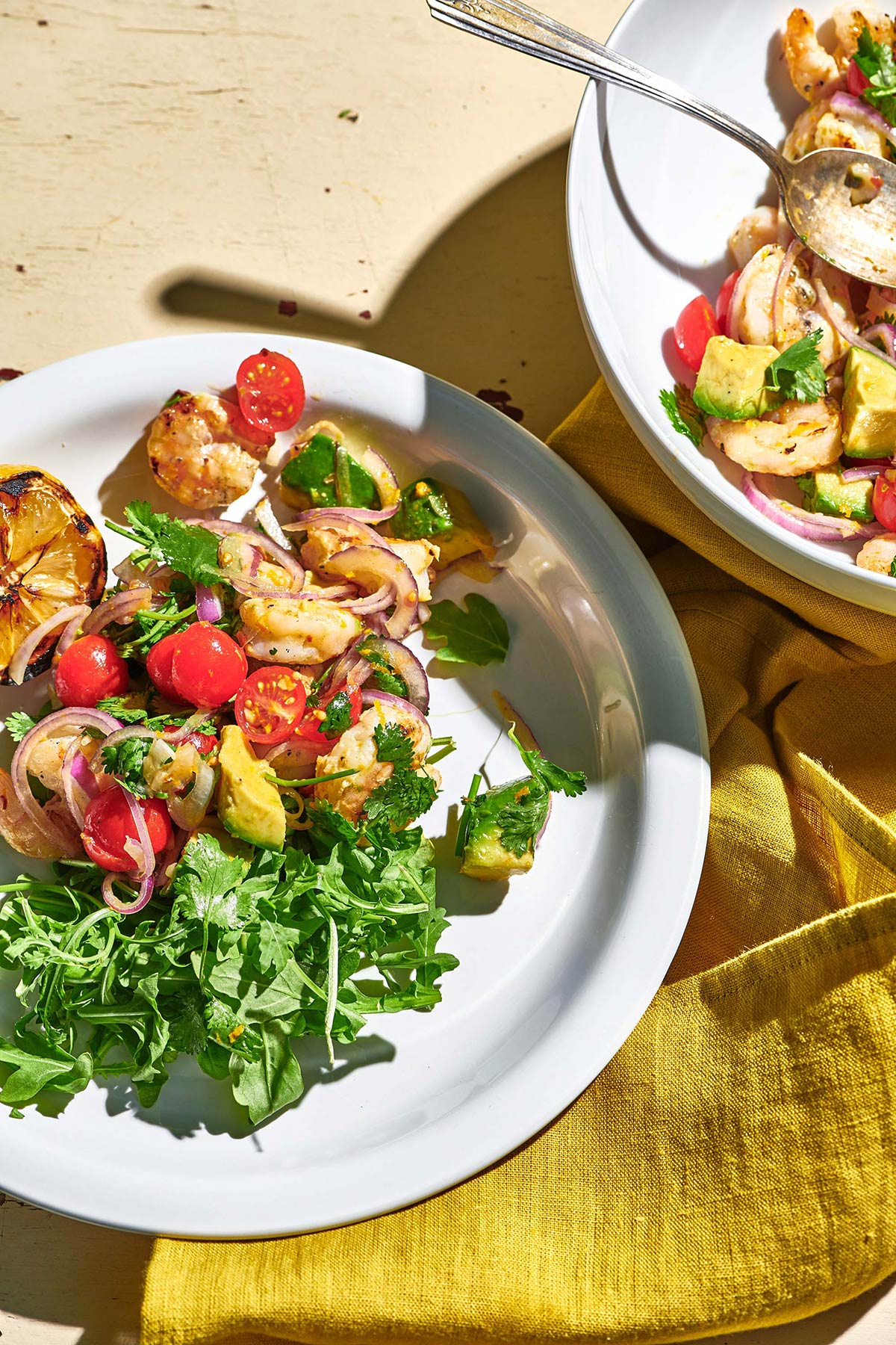 Serving citrus shrimp salad with arugula at summer barbecue.