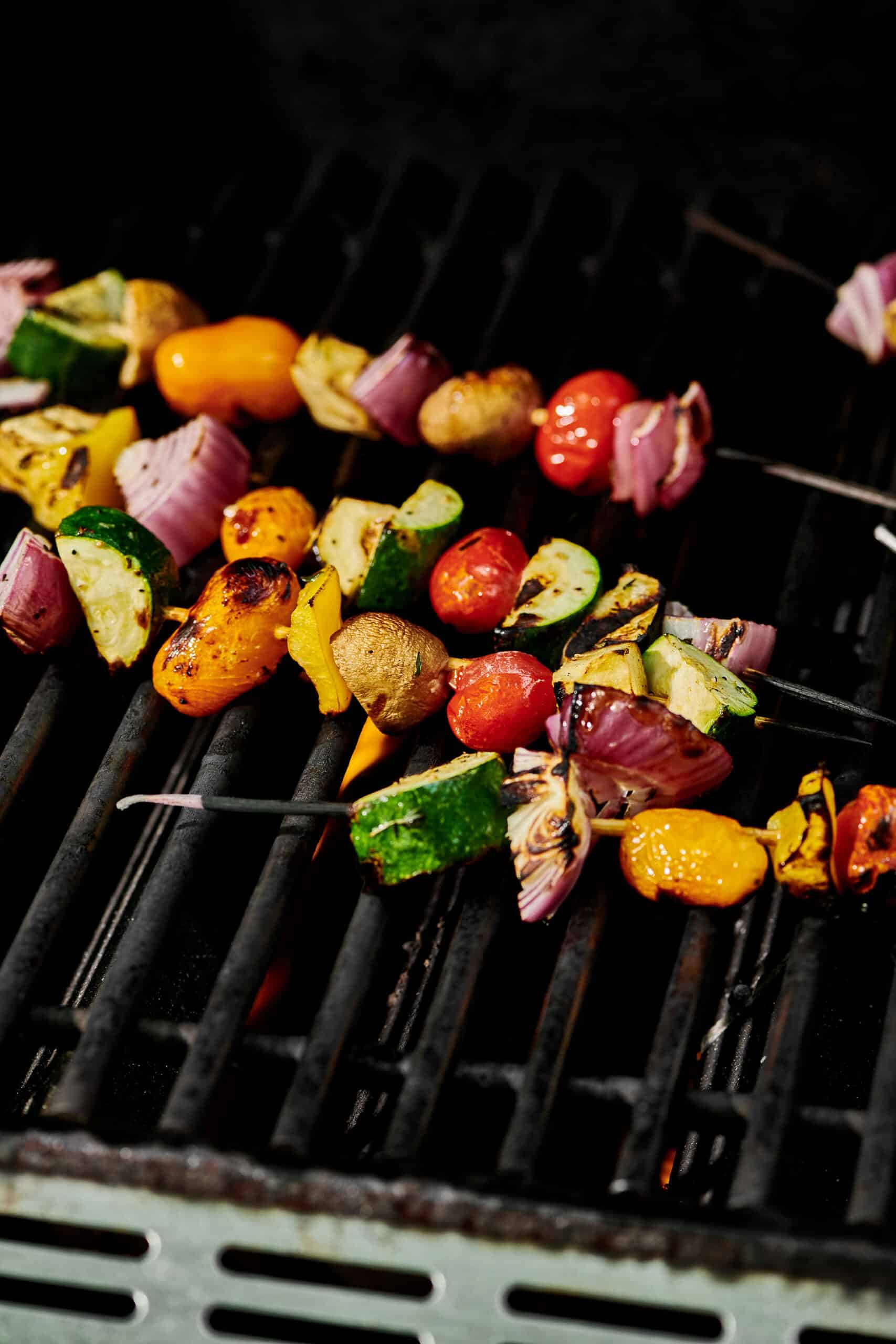 Veggie kebabs cooking on a grill.