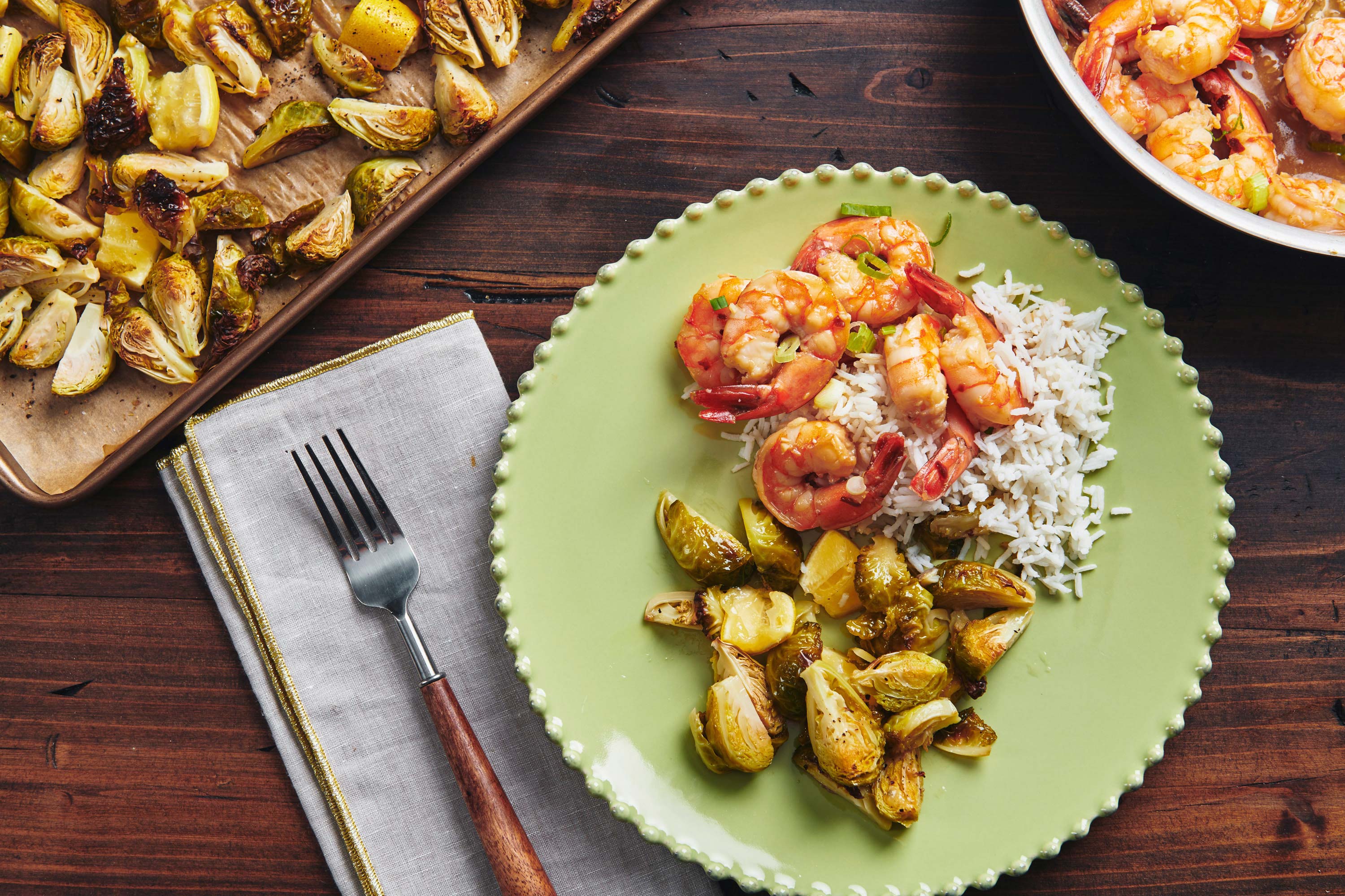 Roasted Lemon Brussels Sprouts on a plate with shrimp over rice.