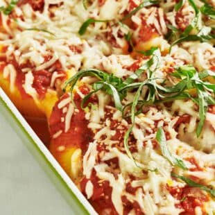 Stuffed Shells topped with mozzarella cheese and basil.
