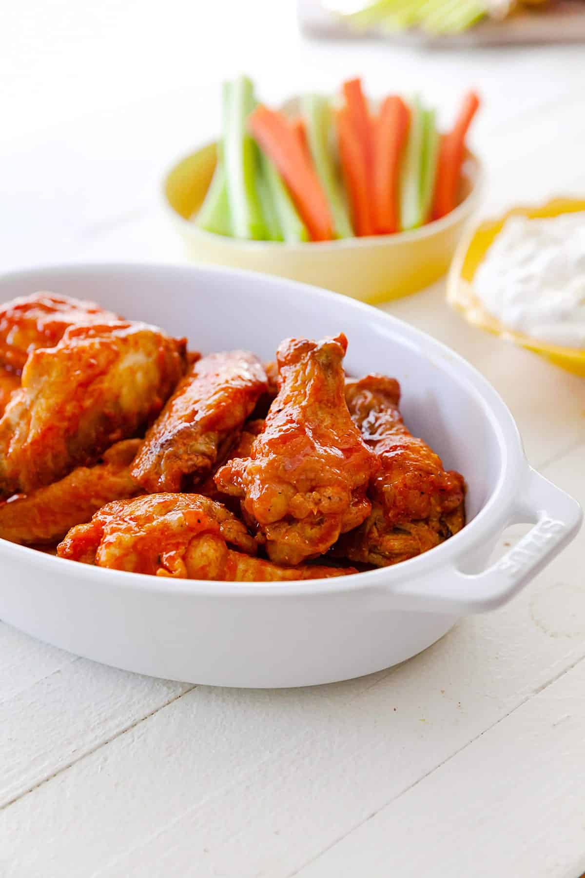 Air Fryer Buffalo Chicken Wings in a white serving dish on table.
