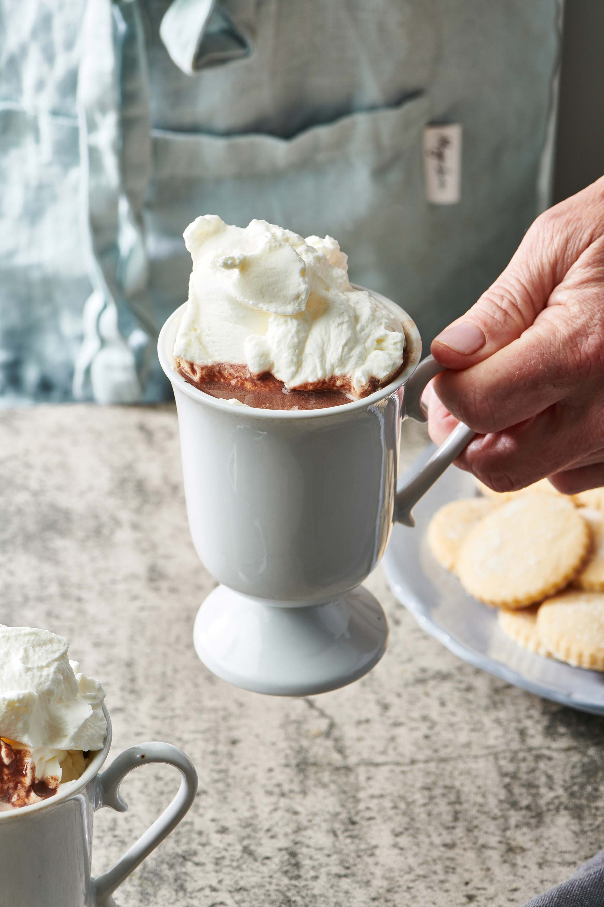 Hand holding a small mug of Hot Chocolate.