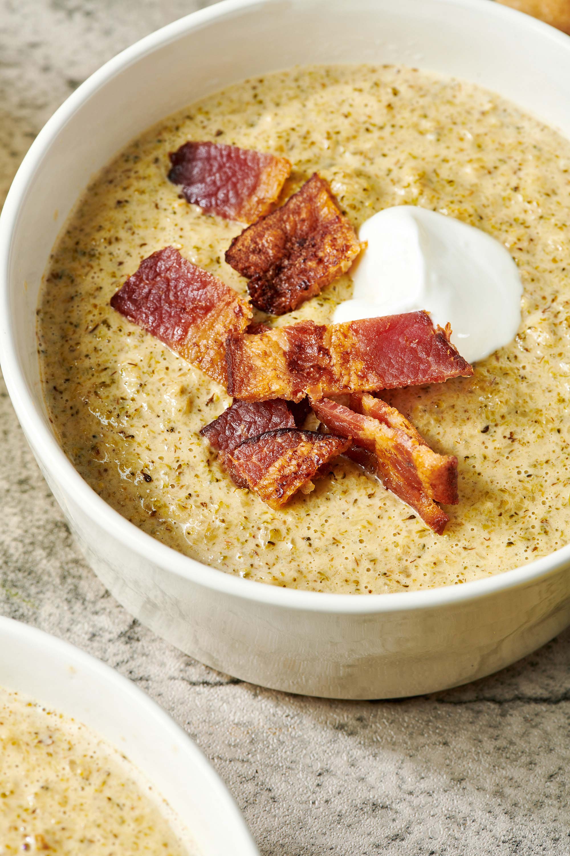 Broccoli Cheddar Soup in bowl topped with bacon.